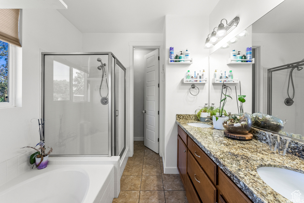 Bathroom featuring a shower stall, double vanity, a garden tub, and tile patterned floors
