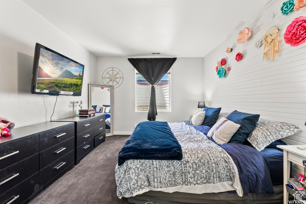 Bedroom with dark colored carpet and baseboards