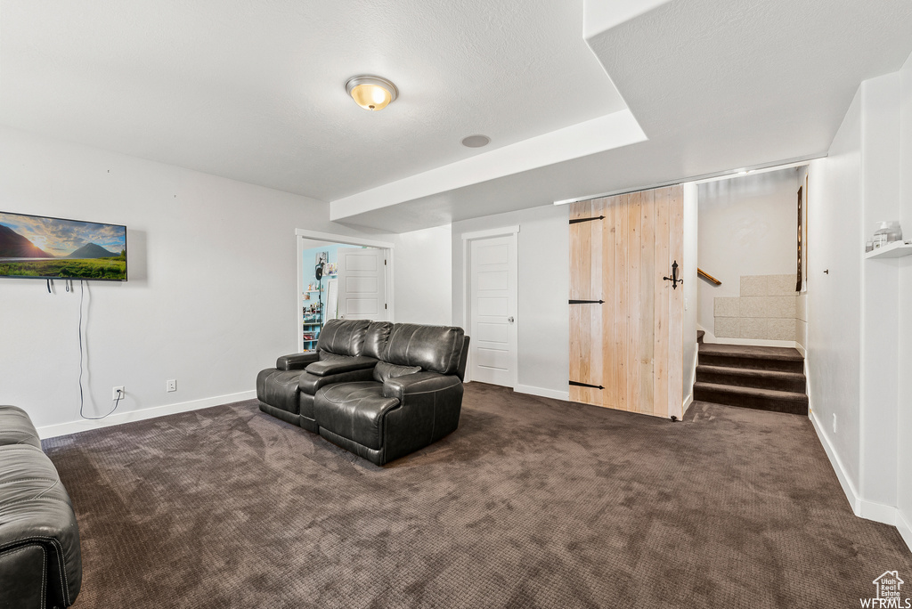 Living room with dark colored carpet and stairs
