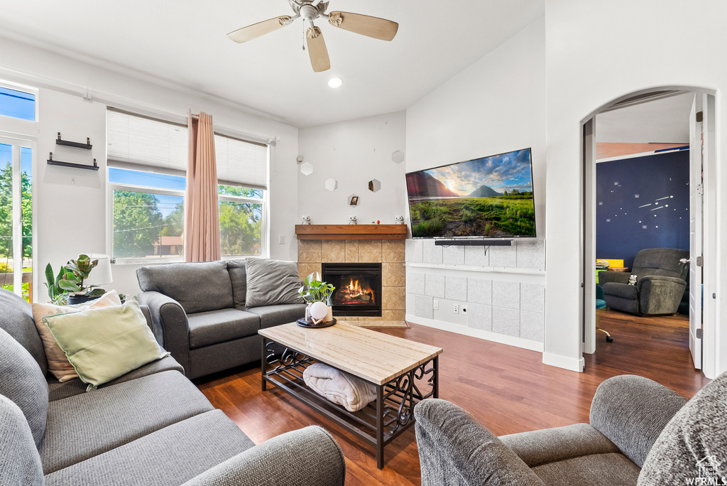 Living room featuring arched walkways, plenty of natural light, wood finished floors, a ceiling fan, and recessed lighting