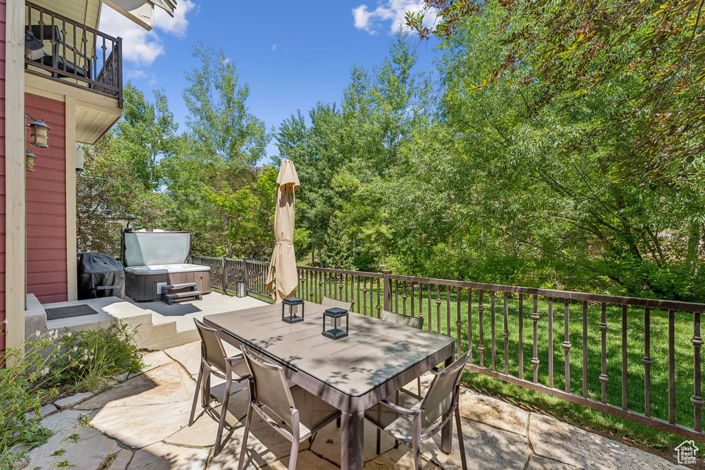 Patio / terrace with a hot tub, outdoor dining space, and a patio