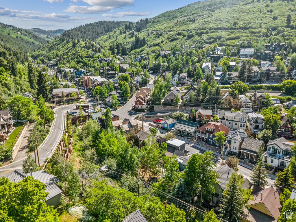 Aerial perspective of suburban area with a mountainous background and a forest