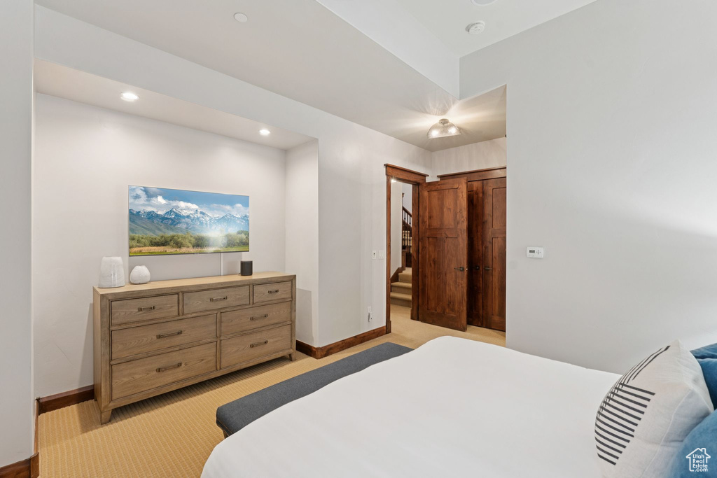Bedroom with light colored carpet and recessed lighting