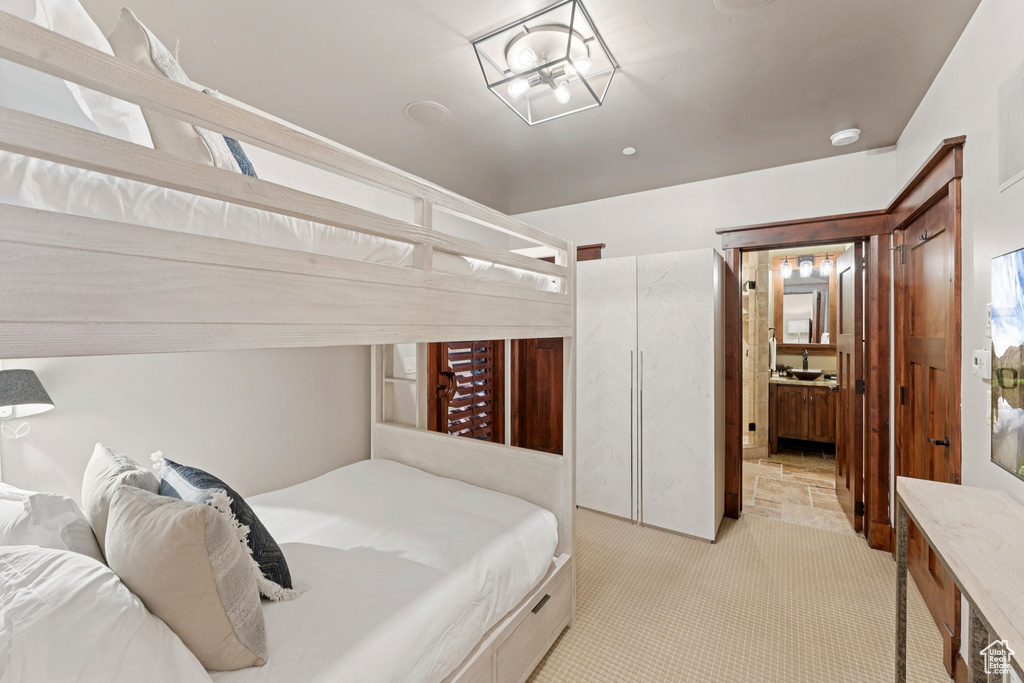 Bedroom featuring light carpet and a sink