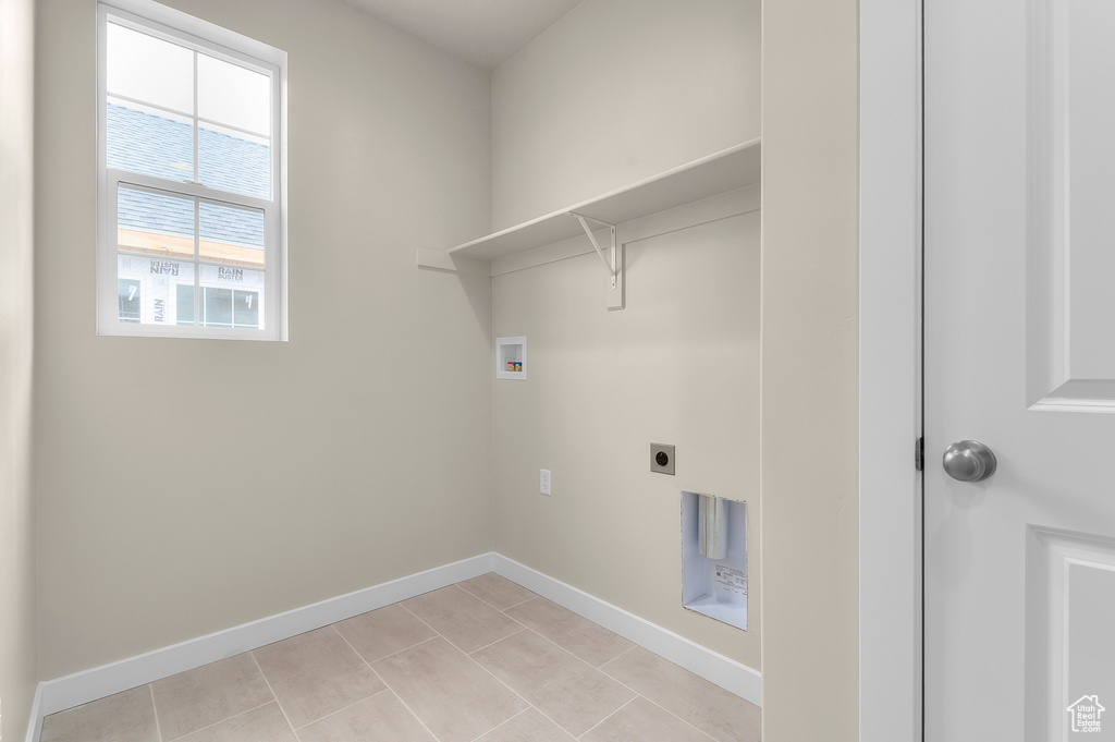 Laundry room featuring washer hookup, electric dryer hookup, and light tile patterned flooring