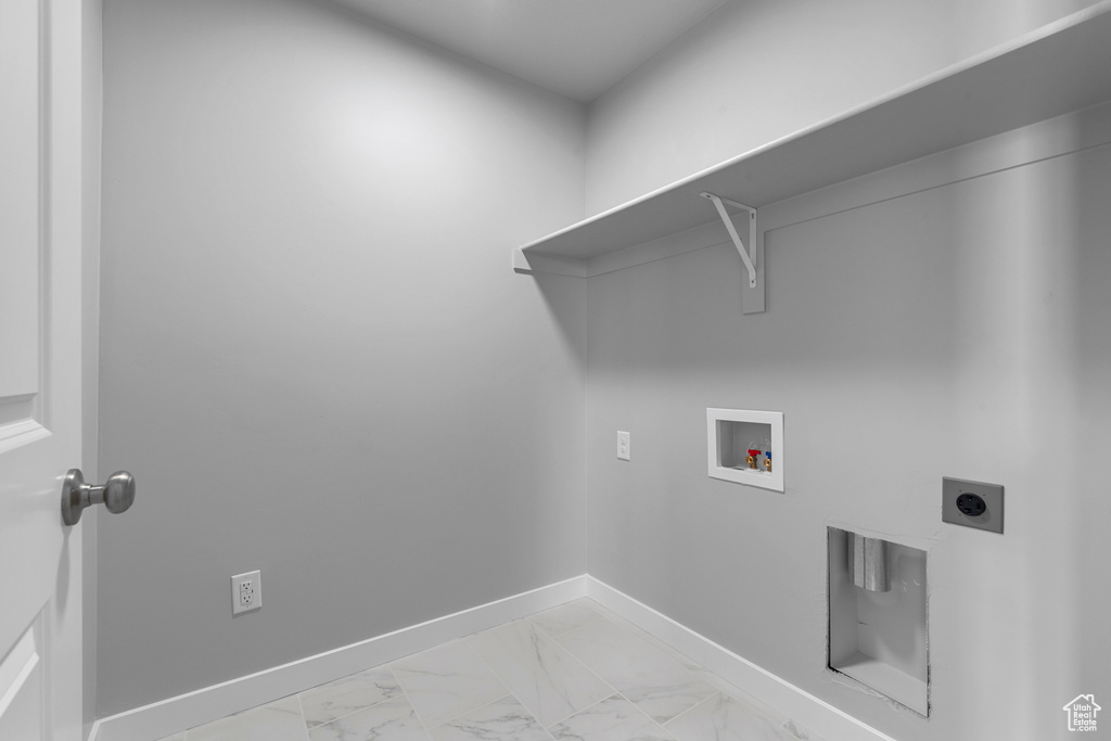 Laundry room with hookup for an electric dryer, hookup for a washing machine, and light marble finish floors