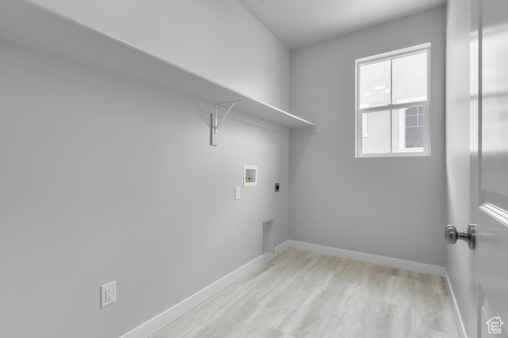 Laundry area with electric dryer hookup, light wood-style floors, and washer hookup