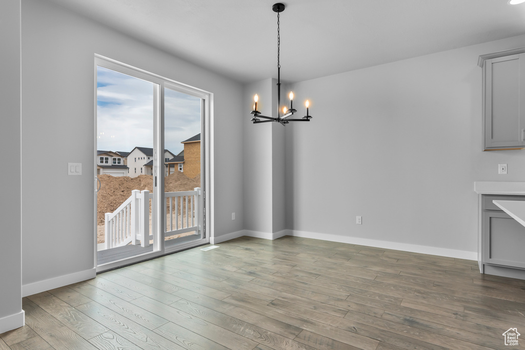 Unfurnished dining area featuring a chandelier and light wood finished floors