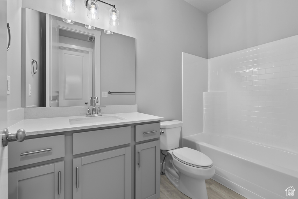 Bathroom featuring vanity, wood finished floors, and bathtub / shower combination