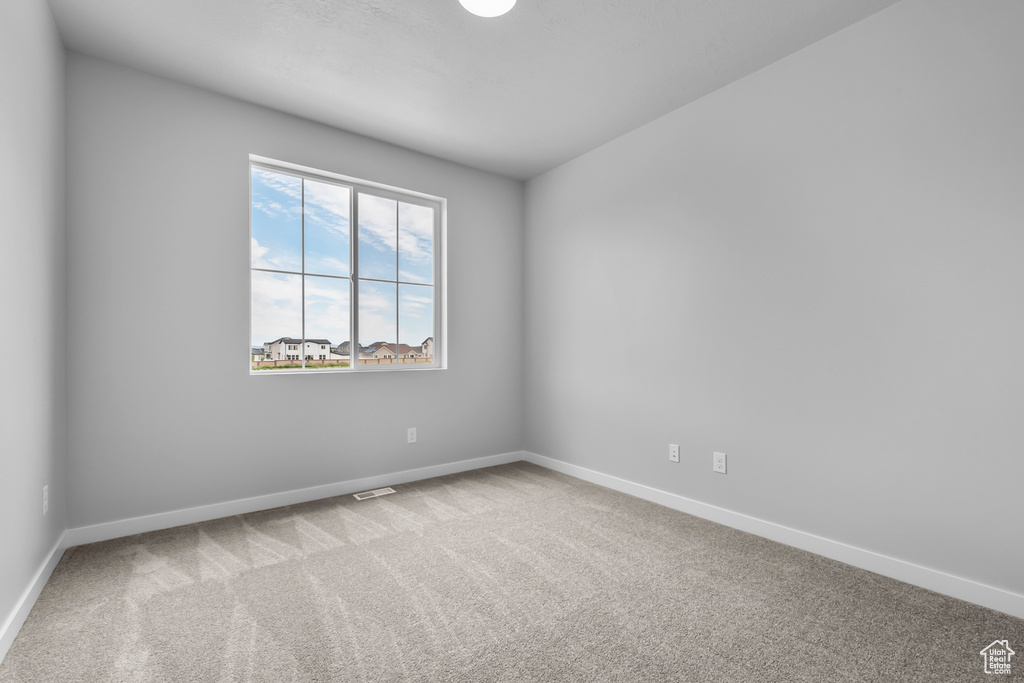 Carpeted empty room featuring baseboards