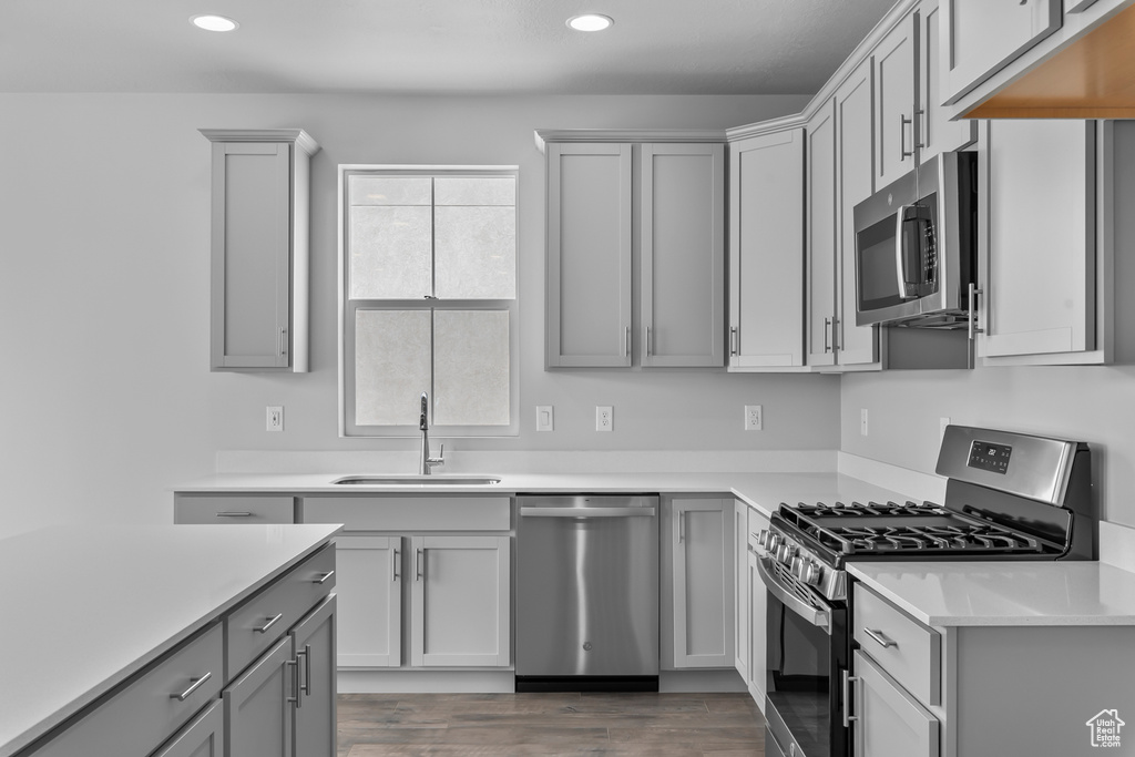 Kitchen featuring stainless steel appliances, recessed lighting, gray cabinetry, and light countertops