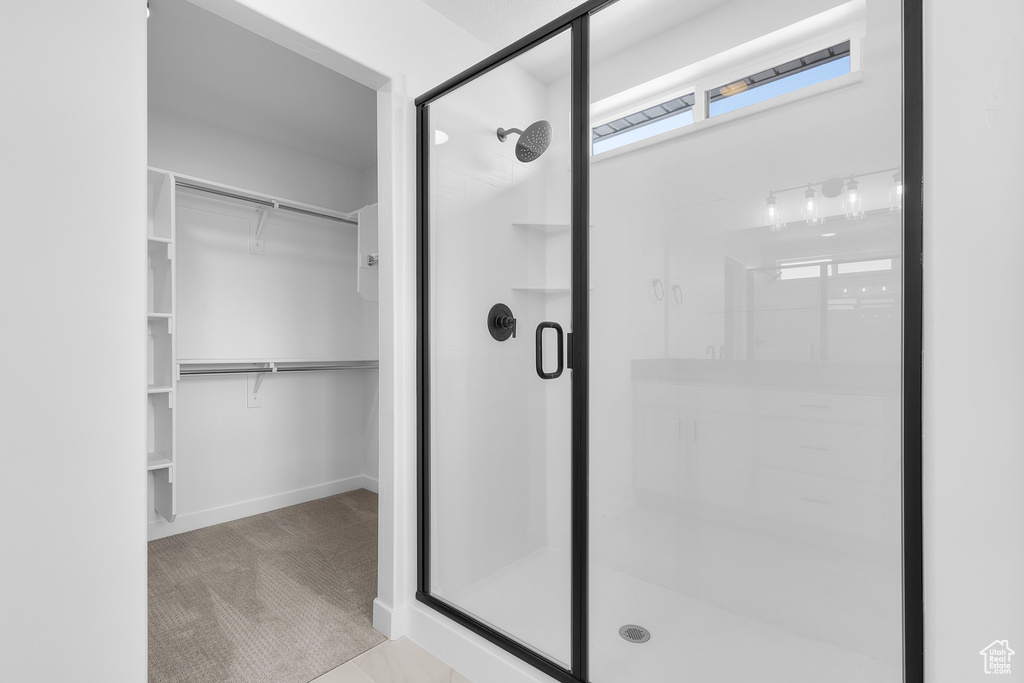 Bathroom featuring a stall shower and a walk in closet