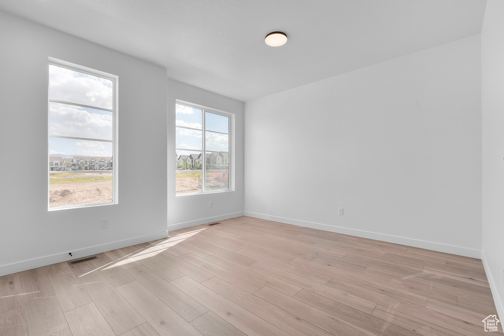Spare room featuring light wood-style floors and baseboards