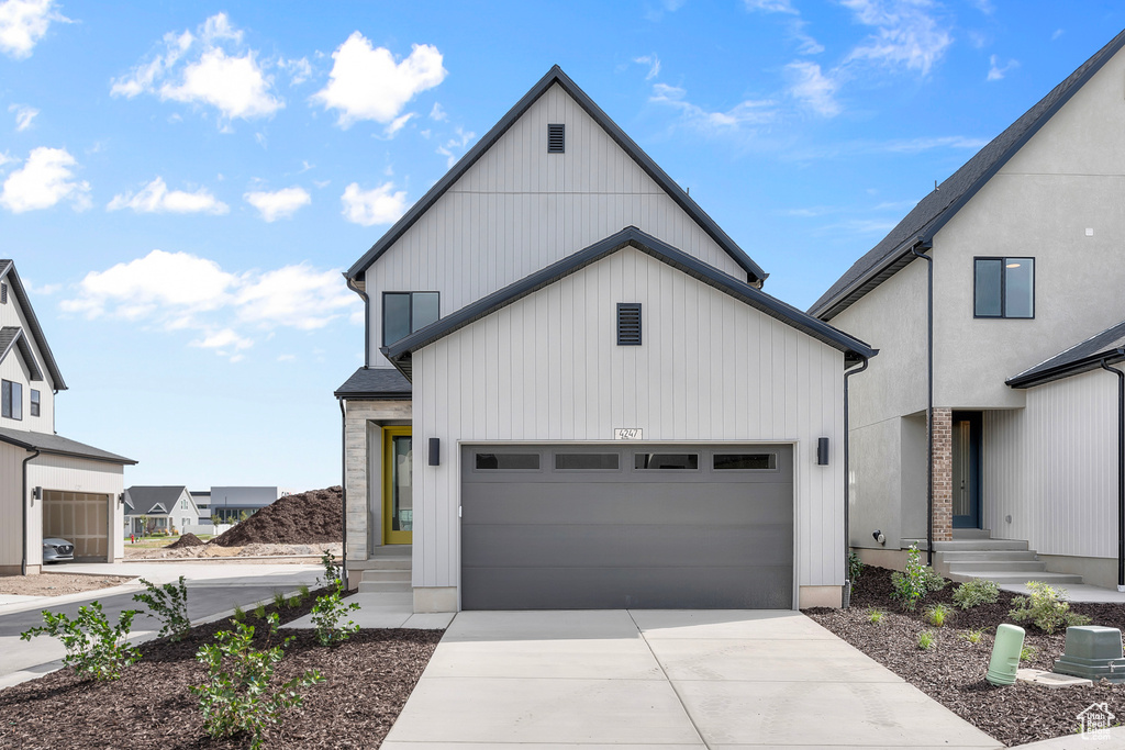 Modern farmhouse with driveway and a garage