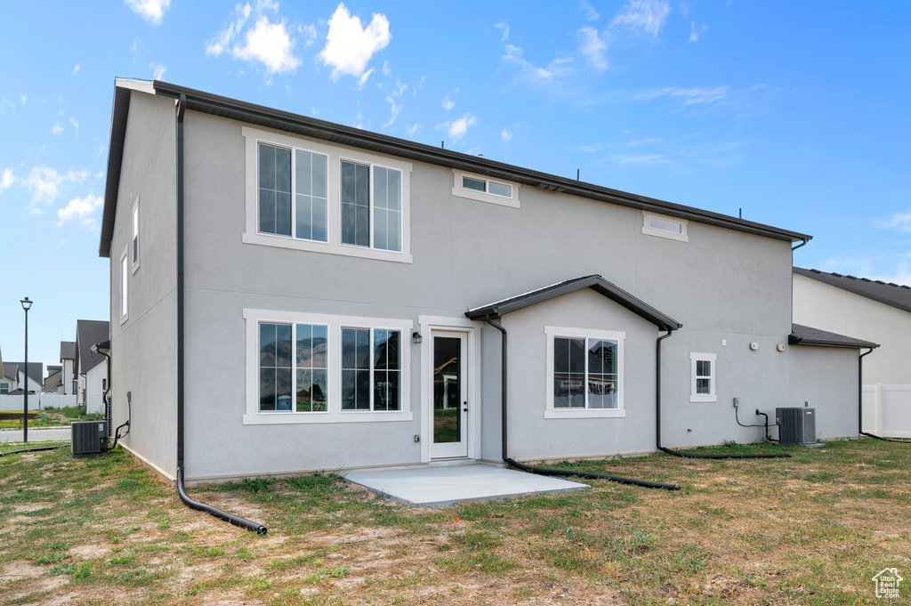 Back of property featuring stucco siding, a patio, and a yard
