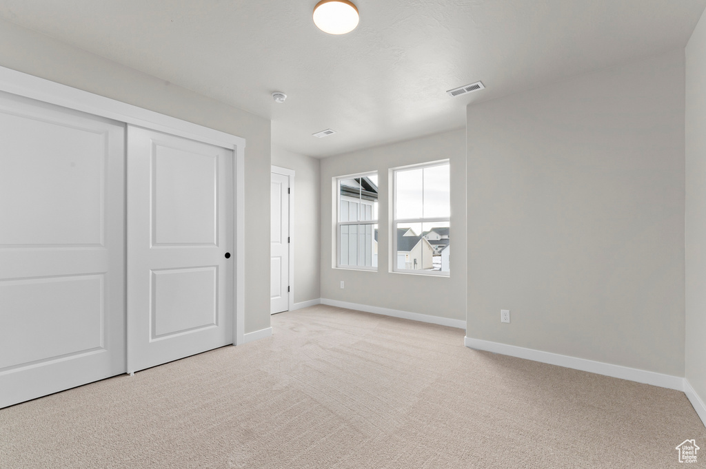 Unfurnished bedroom with carpet flooring and a closet