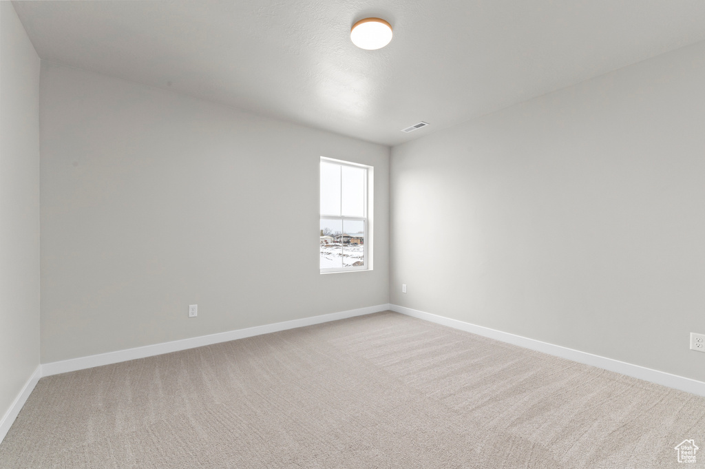 Carpeted empty room featuring baseboards