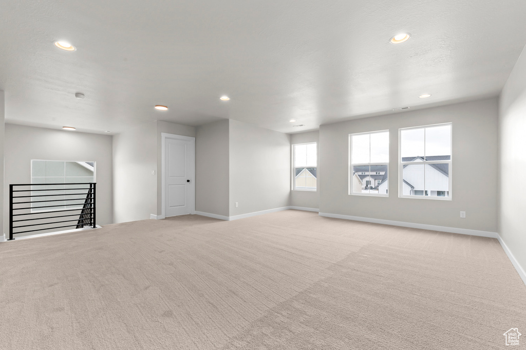 Unfurnished living room featuring light carpet and recessed lighting