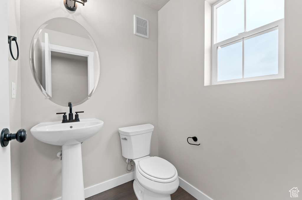 Bathroom with toilet and wood finished floors