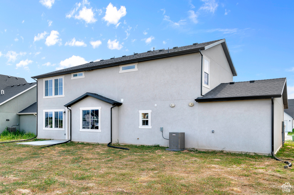 Rear view of property with stucco siding, a yard, and a patio
