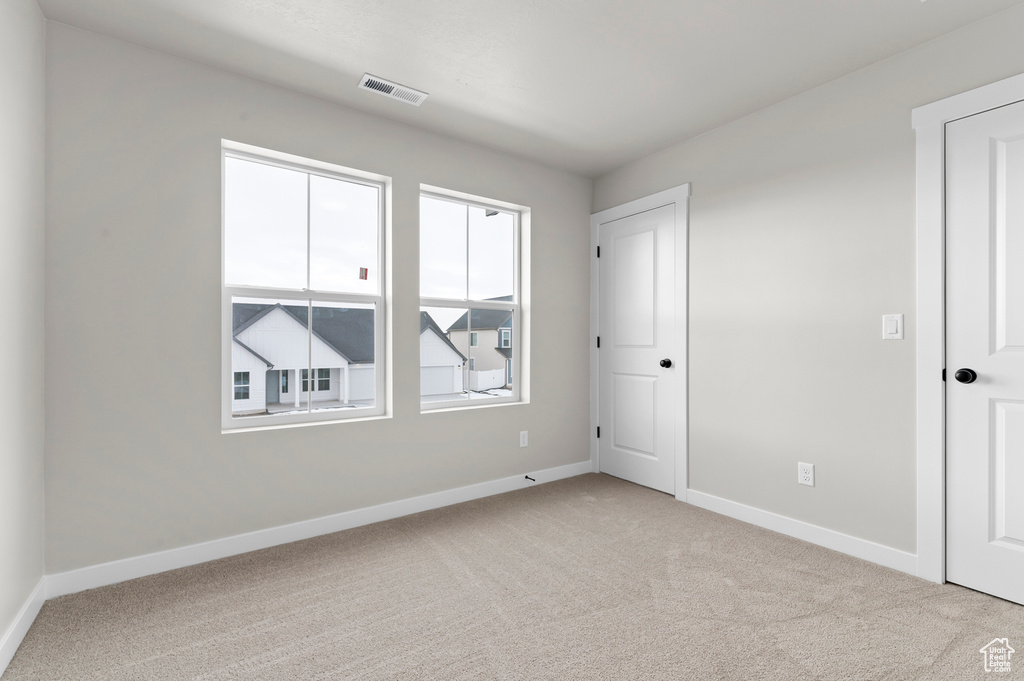 Unfurnished bedroom featuring light colored carpet