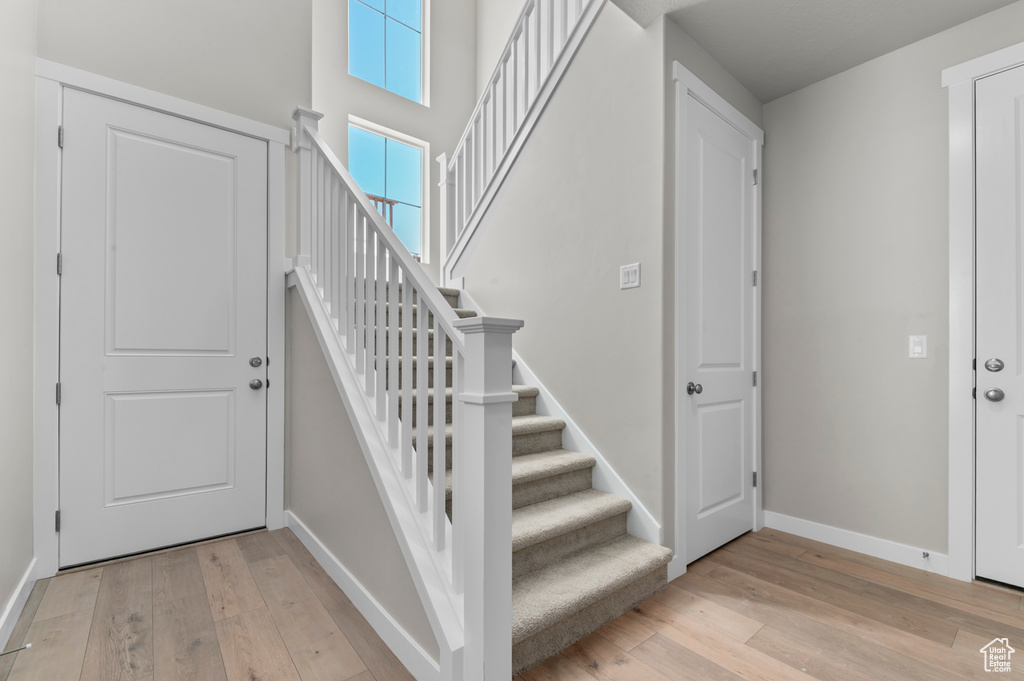 Foyer with light wood-style floors and stairway