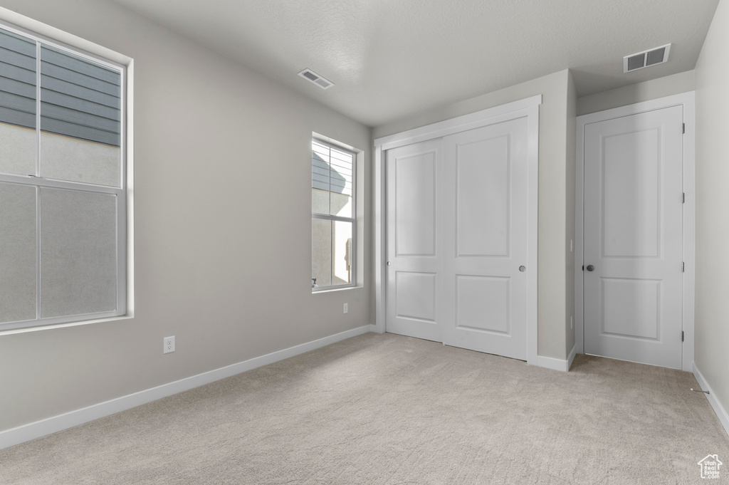 Unfurnished bedroom featuring carpet and a closet