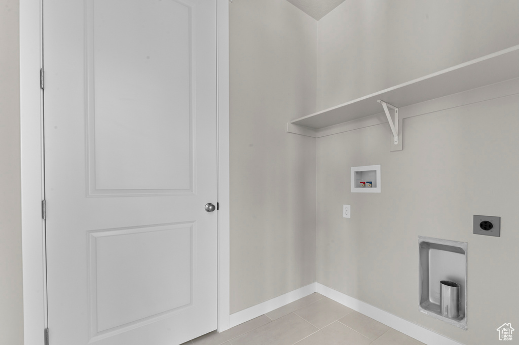Washroom with washer hookup, hookup for an electric dryer, and light tile patterned floors