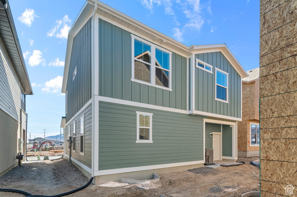 Rear view of property with board and batten siding