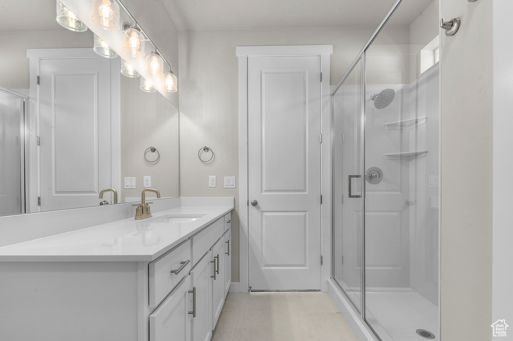 Bathroom with vanity, a shower stall, and tile patterned flooring