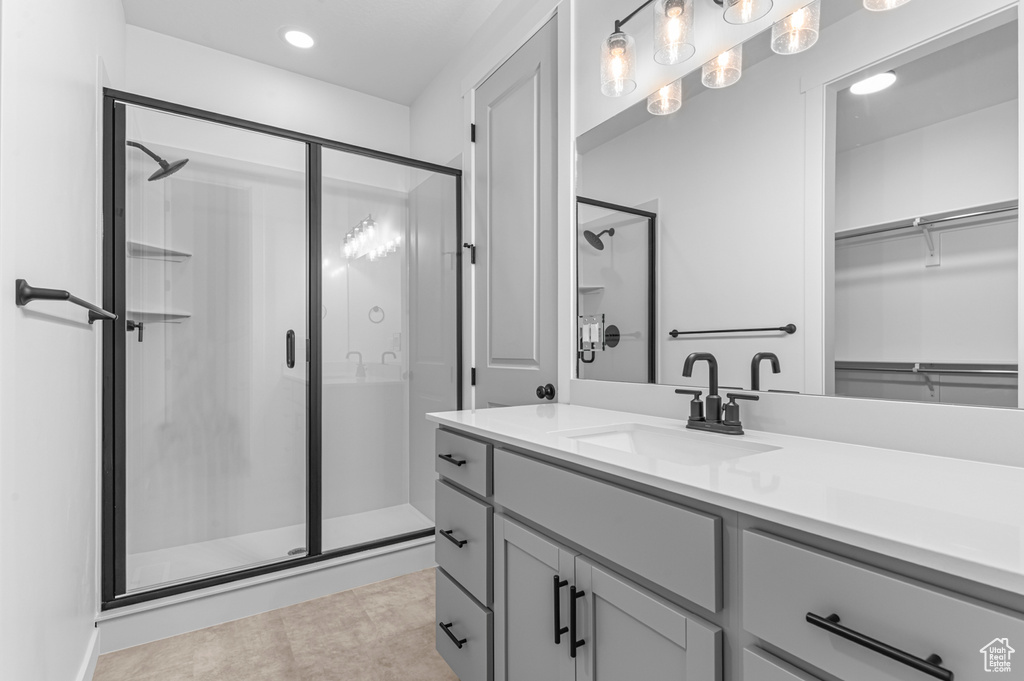 Full bathroom featuring a stall shower, vanity, recessed lighting, a walk in closet, and tile patterned floors