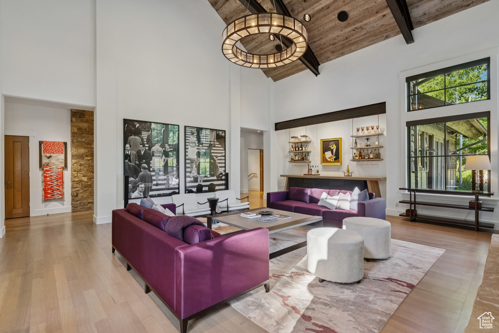 Living area featuring high vaulted ceiling, wood finished floors, and a wood ceiling with exposed beams