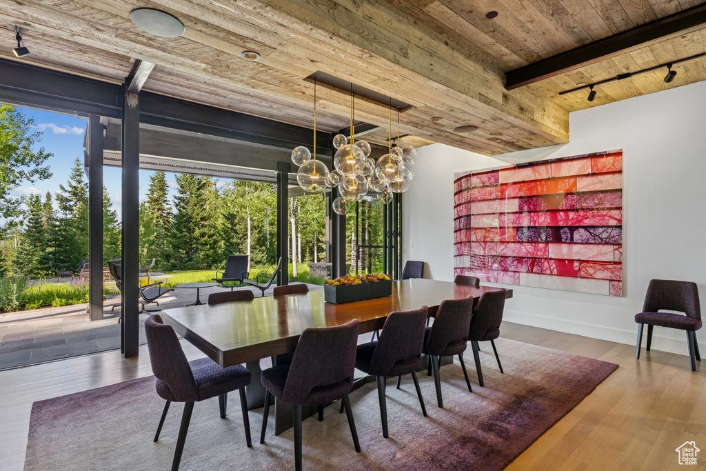Dining room with a wood ceiling with exposed beams, a chandelier, and wood finished floors