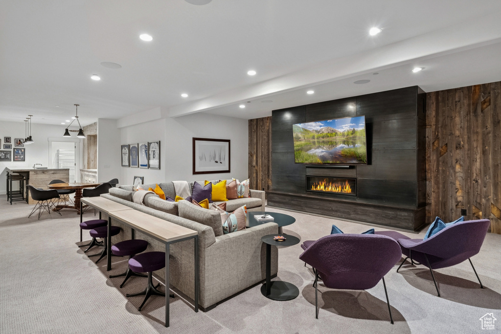 Living area featuring carpet floors, a large fireplace, and recessed lighting