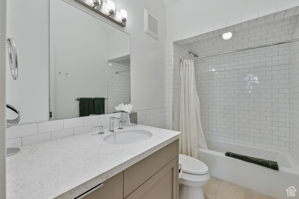 Full bathroom with vanity, shower / bath combo, and tile patterned flooring