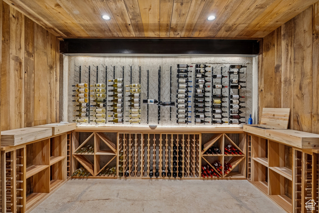 Wine room featuring wooden ceiling, wooden walls, and recessed lighting