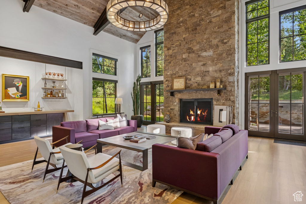 Living area featuring wood finished floors, plenty of natural light, french doors, high vaulted ceiling, and a wooden ceiling with exposed beams