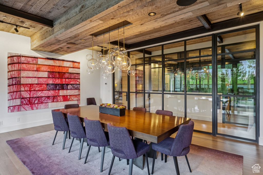 Dining area with a wooden ceiling with exposed beams, healthy amount of natural light, and wood finished floors