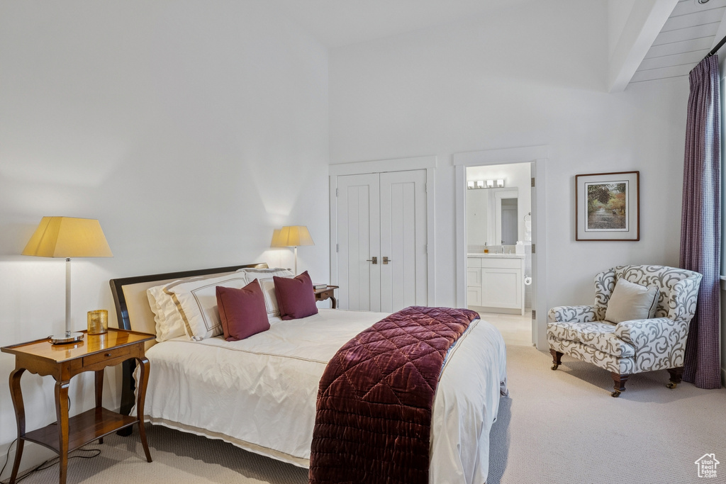 Carpeted bedroom featuring high vaulted ceiling, a closet, and connected bathroom
