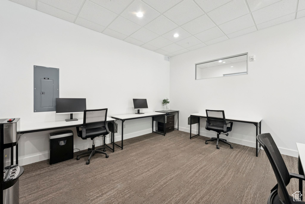 Office featuring electric panel, carpet floors, a drop ceiling, and recessed lighting