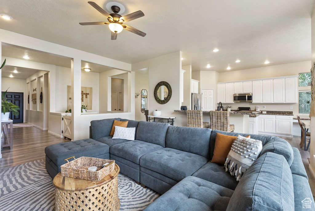 Living room with wood finished floors, ceiling fan, and recessed lighting