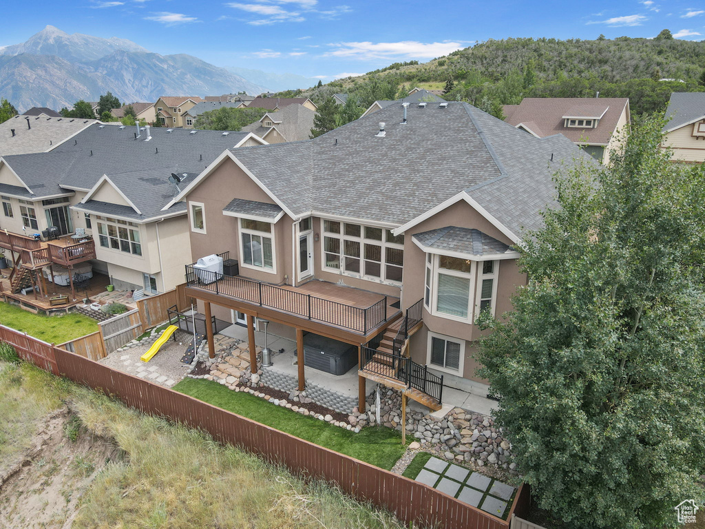 Back of property with roof with shingles, a fenced backyard, stairs, and a patio area