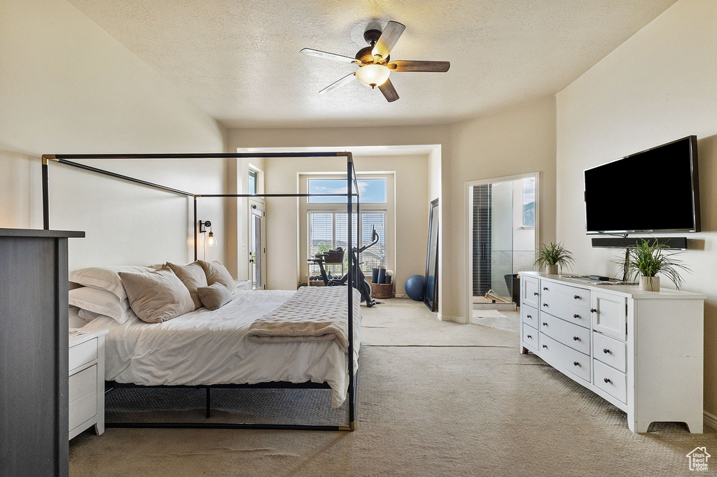 Bedroom with light carpet, a textured ceiling, access to exterior, and a ceiling fan