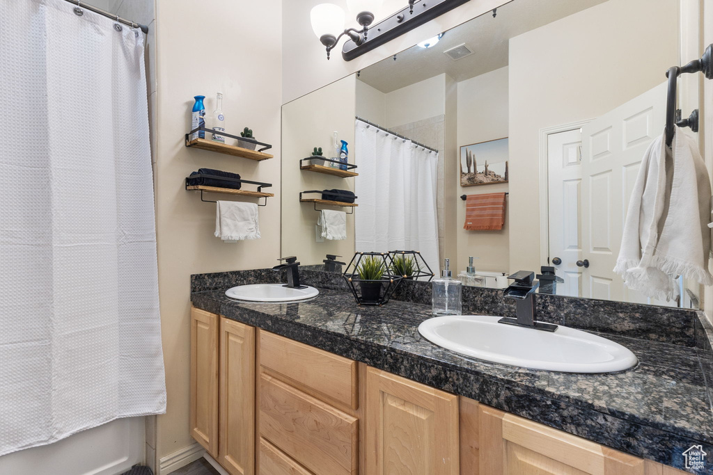 Full bathroom with double vanity and curtained shower