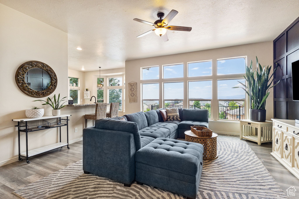 Living room featuring plenty of natural light, wood finished floors, ceiling fan, and recessed lighting