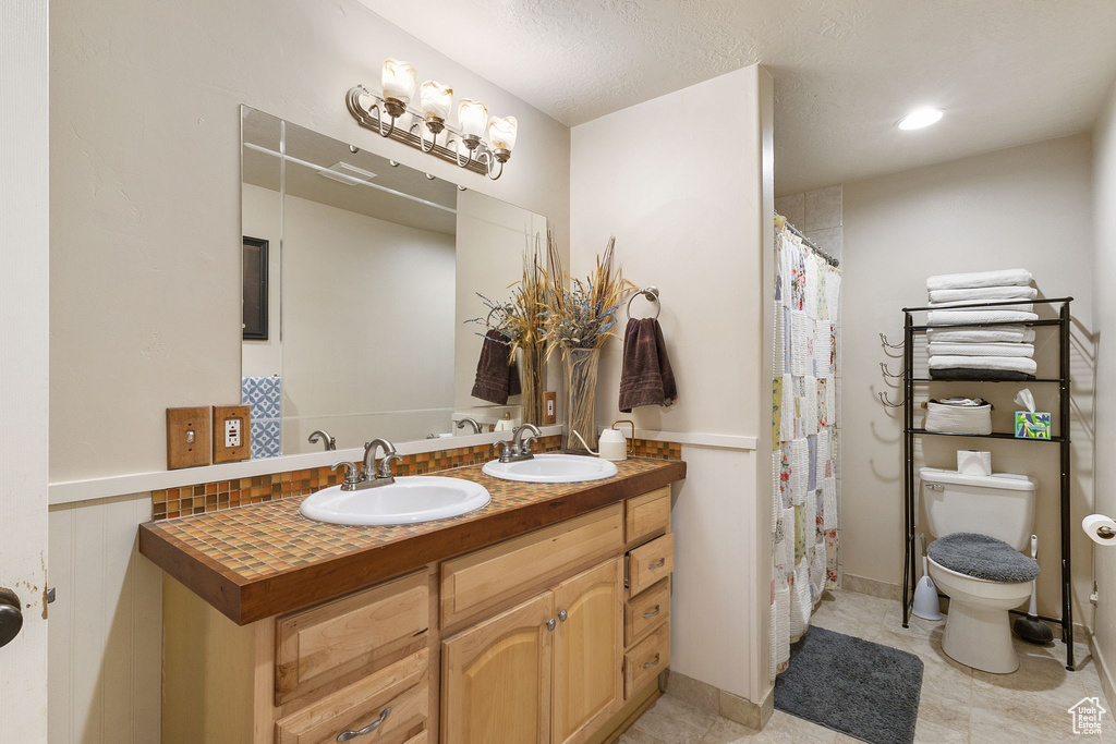 Bathroom featuring double vanity and curtained shower
