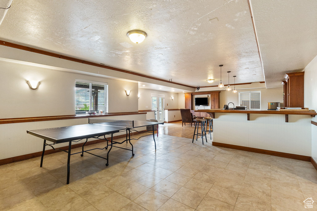 Game room featuring a textured ceiling and baseboards
