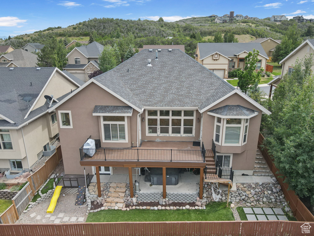 Rear view of property featuring roof with shingles, a patio area, stucco siding, a fenced backyard, and stairway