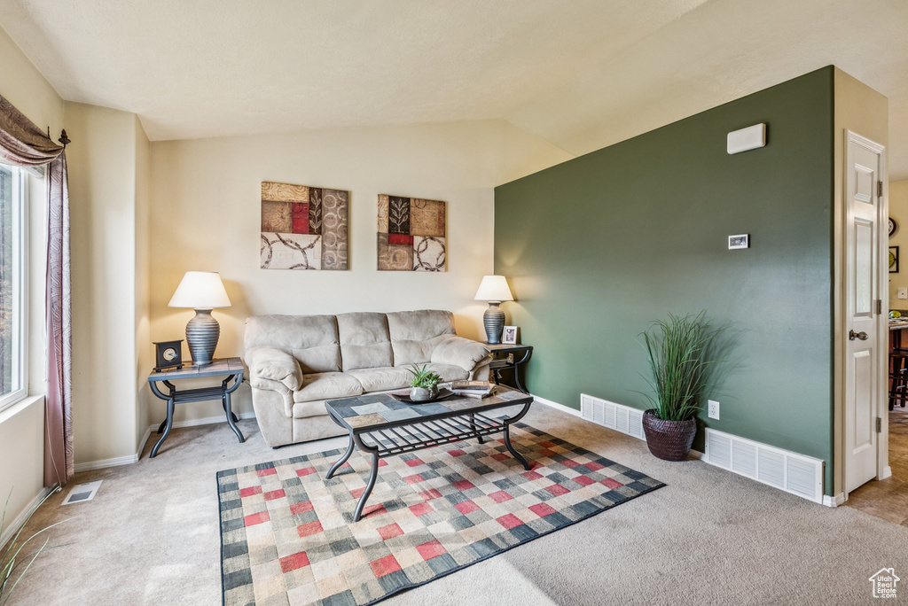 Living room featuring carpet and vaulted ceiling