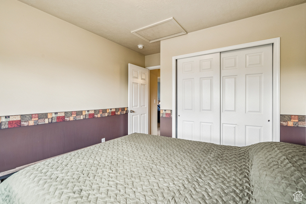 Bedroom with attic access and a closet